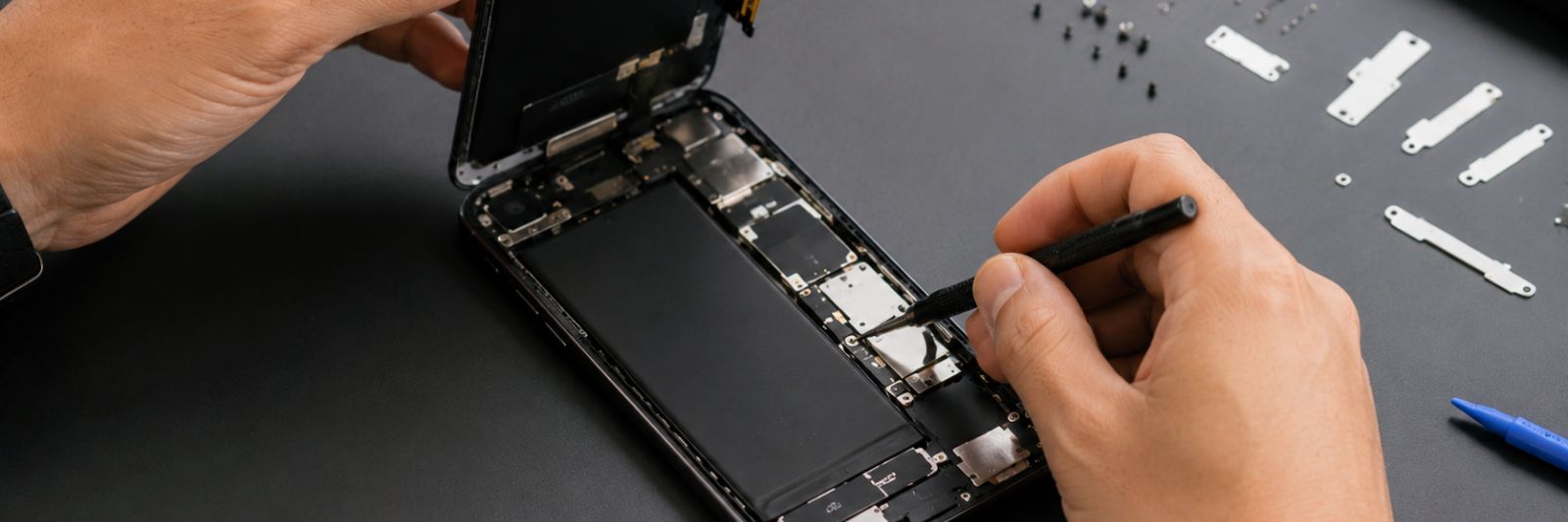Smartphone wird auf einem Tisch mit Werkzeug repariert