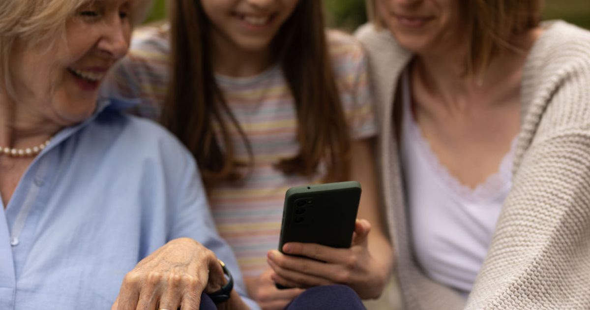 3 Personen schauen gemeinsam auf ein Smartphone